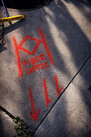 Fibre optic line marked and labelled on a concrete sidewalk